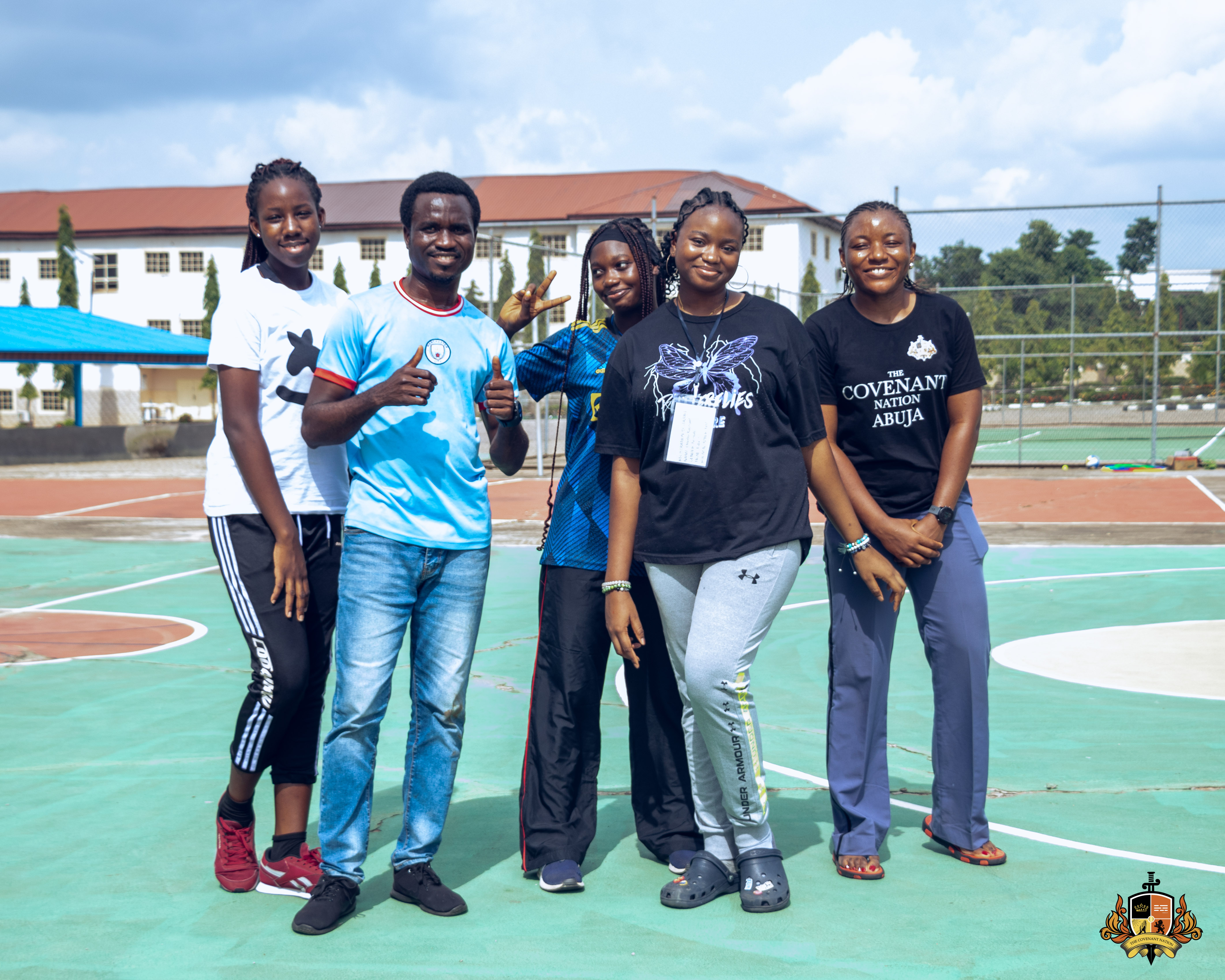 A group of campers smiling together on the court